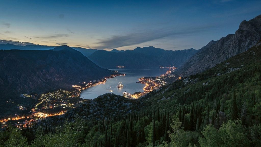 Avondzicht op de verlichte Baai van Kotor, een indrukwekkende stop in het goedkoopste vakantieland Europa